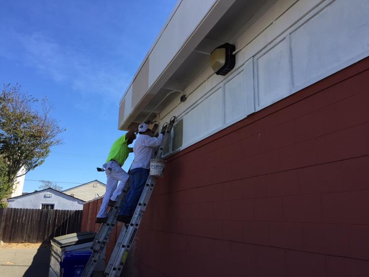 Larry Oraboni and Wilber Gomez painting the exterior of Dispatch Center